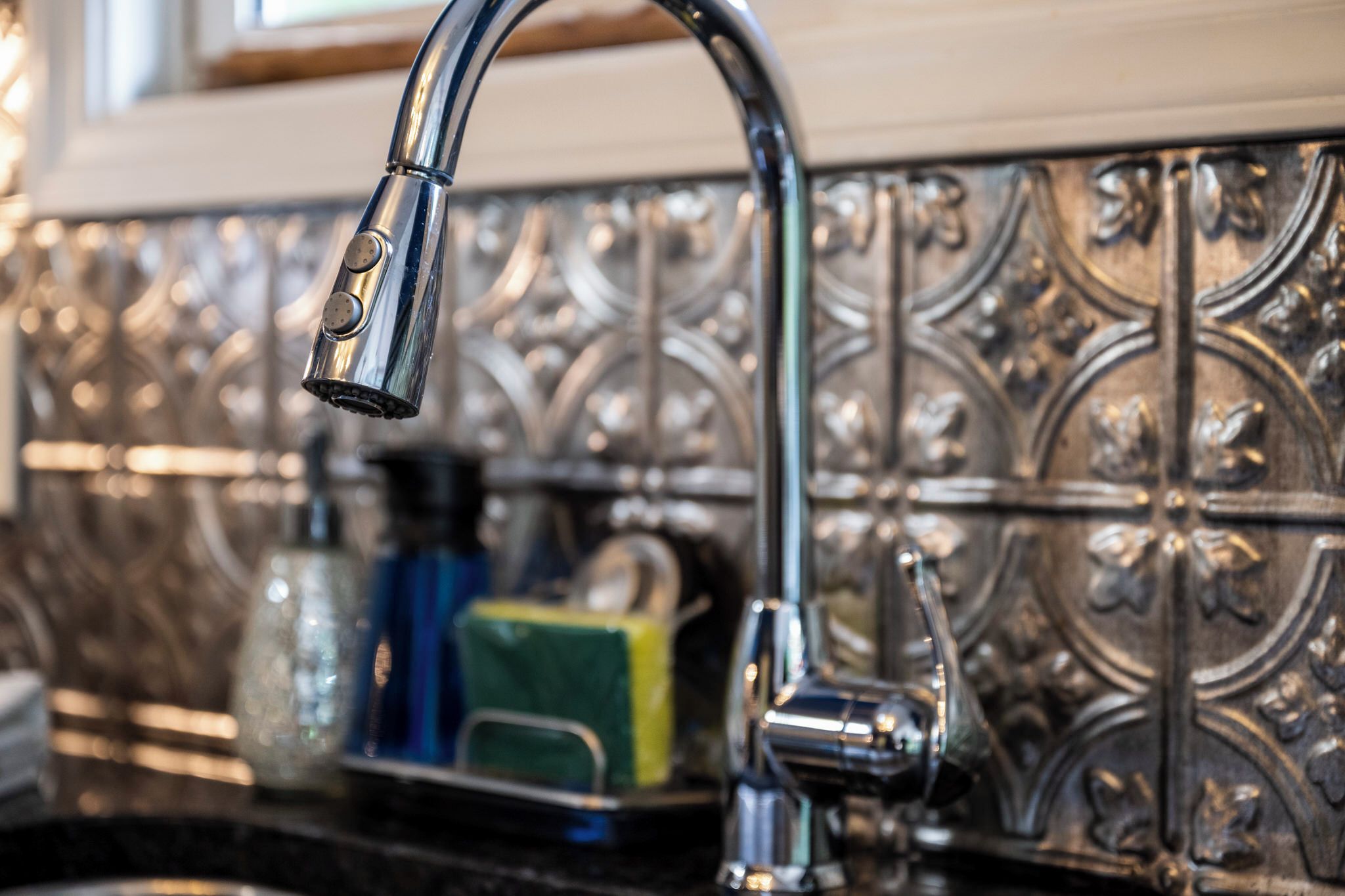 Una cocina con un grifo moderno y un salpicadero decorativo.