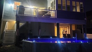 Una casa de dos pisos con balcón, piscina y una bandera estadounidense.
