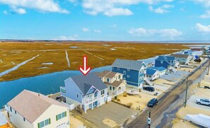 A coastal residential area with houses along a road, a body of water, and a clear sky. - Sunset Vista Home with POOL (Tuckerton)