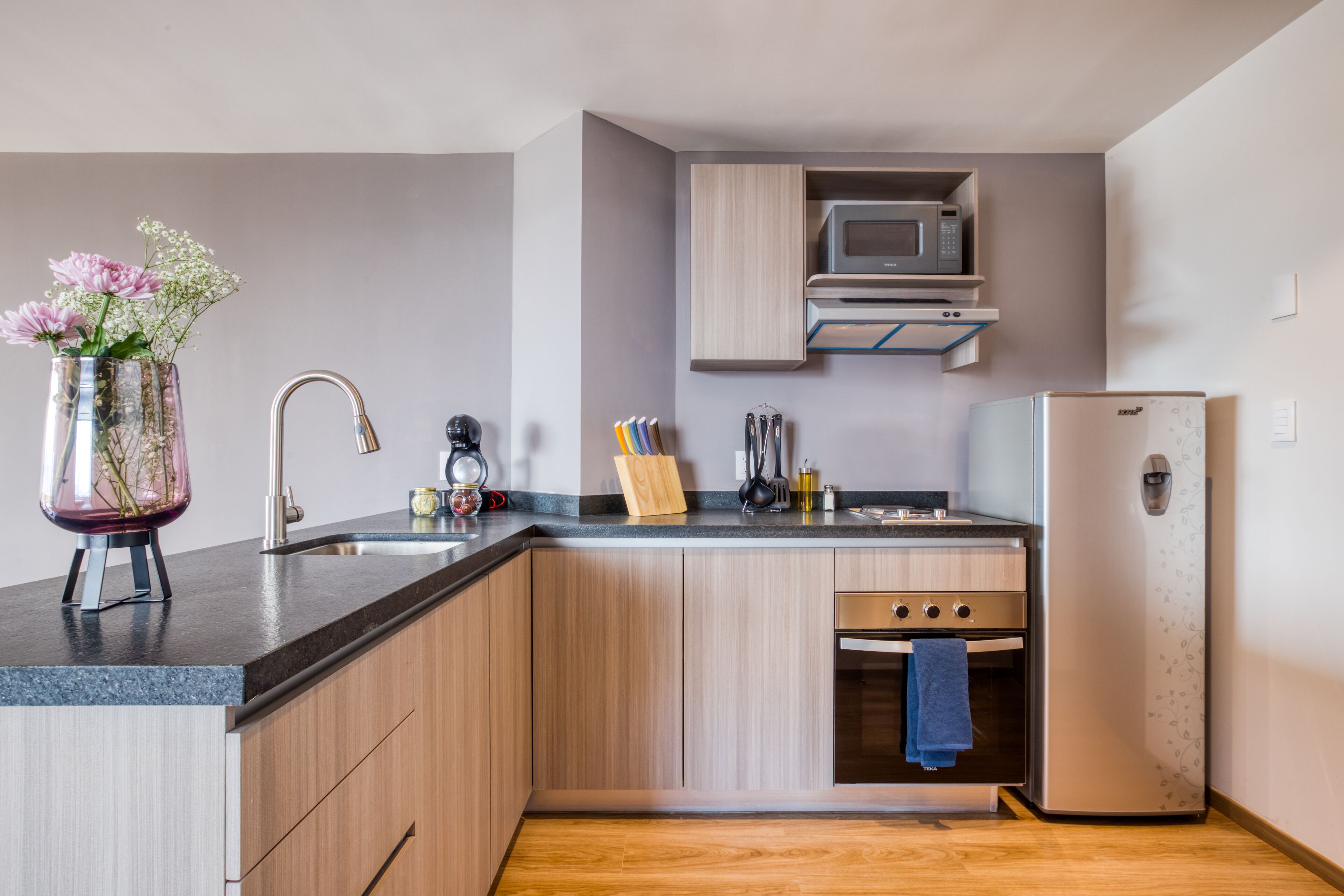 A modern kitchen with a built-in microwave, oven, and refrigerator.
