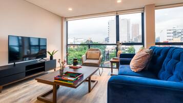 Exclusive Three-Bedroom Apartment | Área de sala de estar | Smart TV de 42 pulgadas con canales digitales y televisión