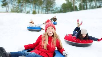 Personas deslizándose cuesta abajo sobre la nieve.