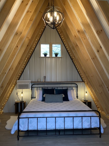 King bed in Tulip Glamping Aframe at Noble Pine Campground