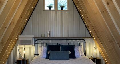 King bed in Tulip Glamping Aframe at Noble Pine Campground