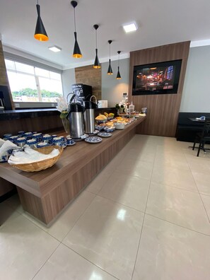 A buffet setup with various food items and a coffee station. - Pousada Saint Diniz (Monte Sião)