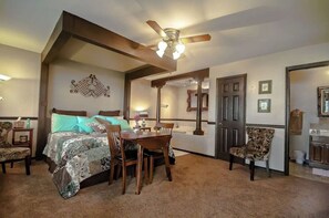Relax in this inviting room with a large bed, dining table, and comfortable seating area.