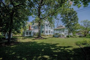 Stroll through the grounds of this charming home, surrounded by lush trees and a well-manicured lawn.