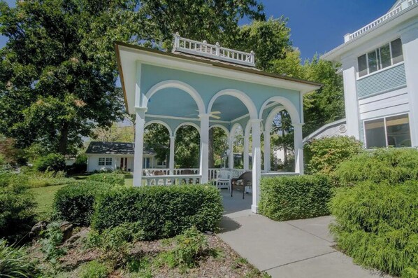 Relax in a serene outdoor space surrounded by lush greenery and a beautifully designed gazebo.