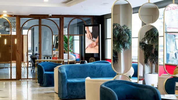 A modern lobby with blue sofas, a reception desk, and large mirrors. - Jaff Hotels & SPA Nişantaşı (Istanbul)