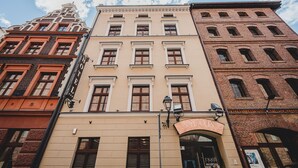 Una hilera de edificios históricos con estilos arquitectónicos distintos, incluyendo un edificio con un letrero que dice "SILVIA'S RECEPTION".