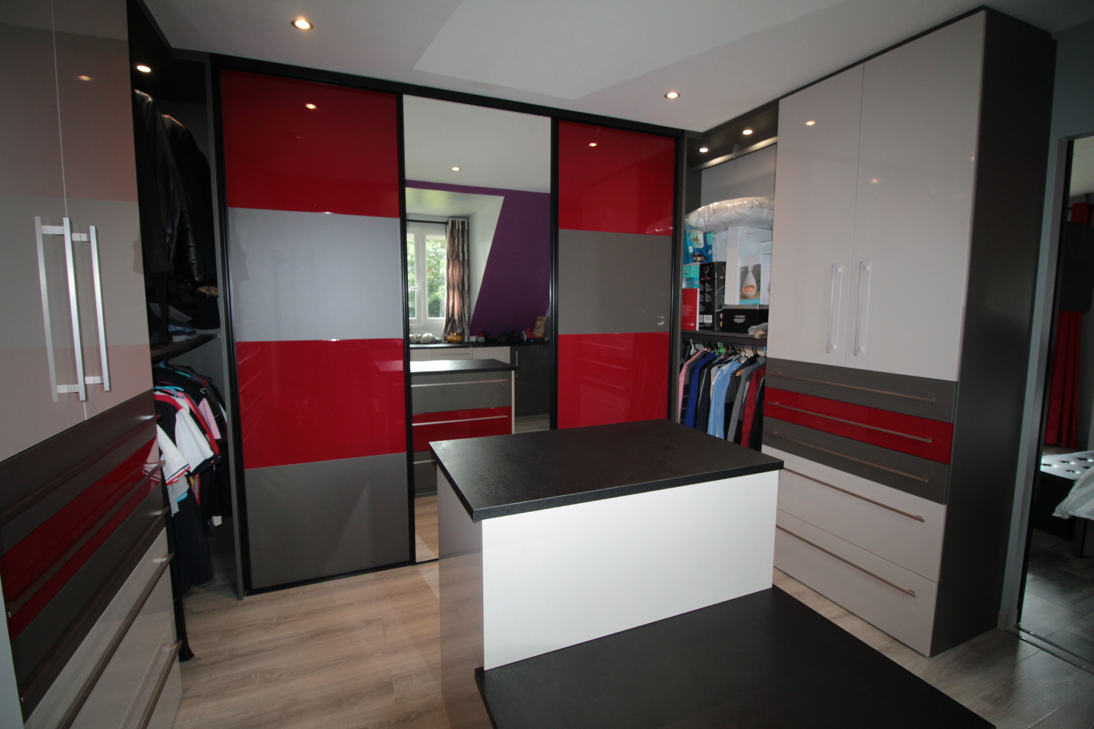 A modern kitchen with a central island, a built-in oven, and a refrigerator.