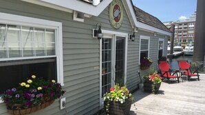 A waterfront building with a sign reading "Green Turtle." It features a wooden deck with outdoor seating and flower planters along the side.