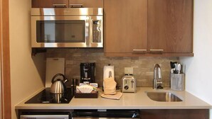 Une cuisine moderne équipée d’appareils électroménagers en acier inoxydable, notamment un four à micro-ondes, un grille-pain et une bouilloire.