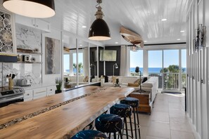 Enjoy ocean views from the kitchen and dining area, featuring a long bar counter and unique ceiling design.