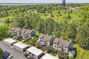 Una zona residenziale con diverse case a due piani, un parcheggio e un campo da golf sullo sfondo.