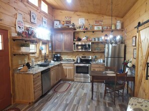 Enjoy cooking in this cabin-style kitchen with a large island, sink, oven, microwave, and refrigerator.
