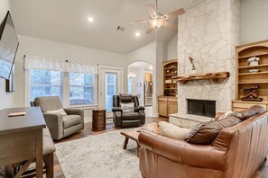 A modern living room with a fireplace, leather sofas, and a dining area.