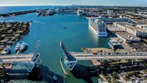 Un grand navire de croisière a accosté dans un port doté de plusieurs ponts et de nombreux terminaux.