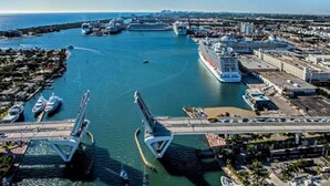 A coastal marina with multiple cruise ships docked, a bridge connecting the land to the water, and a cityscape in the background. - Ocean Flats #3 - Lauderdale-by-the-Sea (Lauderdale-by-the-Sea)