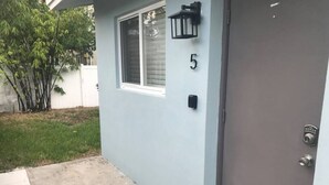 A house with a grey door, a number '5' on the wall, and a small window.