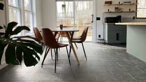 A modern kitchen with a dining area, large windows, and a view of the outdoors. - Convenient Getaway in the Heart of Hudson Valley (Tillson)