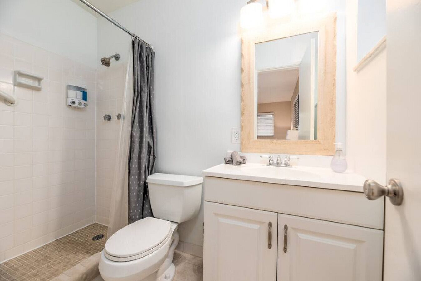 A bathroom with a toilet, shower, and sink.