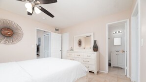 A bedroom with a bed, a dresser, a vanity, and a ceiling fan. - The Retreat #1 - Wilton Manors (Wilton Manors)