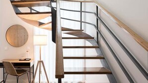 A modern spiral staircase with wooden steps and metal railings, leading to an upper floor. - GuestReady - Porto by the Bridge (Vila Nova de Gaia)
