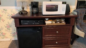 A compact kitchen area with a coffee maker, microwave, and Haier refrigerator.