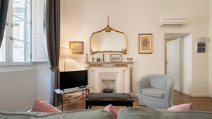 Ein Zimmer mit Kamin, Fernseher, Sessel und Bett.
