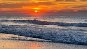 A sunset over the ocean with waves approaching the shore. - Oceanfront Studio Suite with breathtaking views (Myrtle Beach)