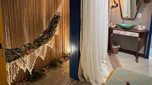 A room with a hammock, a vanity with a mirror, and a bed with flowers. - Villa Lulu Buzios (Búzios)