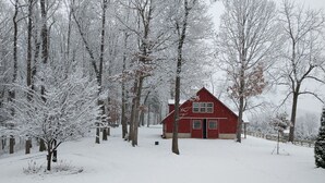 A red cabin surrounded by snow-covered trees in a forest. -  Loft apartment in a working horse barn.  Minutes from Lexington and the  VAHC. (Lexington)