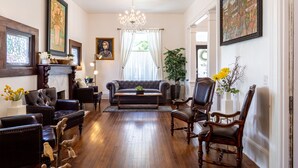 A living room with a fireplace, a sofa, and a chandelier. - Room for Everyone! 7BR, 6.5BA Wine Country Retreat near Downtown (McMinnville)