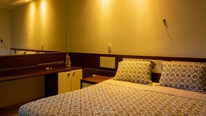 A bedroom with a bed, a nightstand, a dresser, and a mirror. - Hostel Santa Rita (Santa Rita De Cassia)