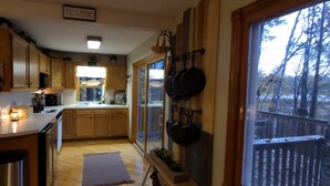 A kitchen with wooden cabinets, a window with a view of trees, and a sign that reads "Meals & Memories".