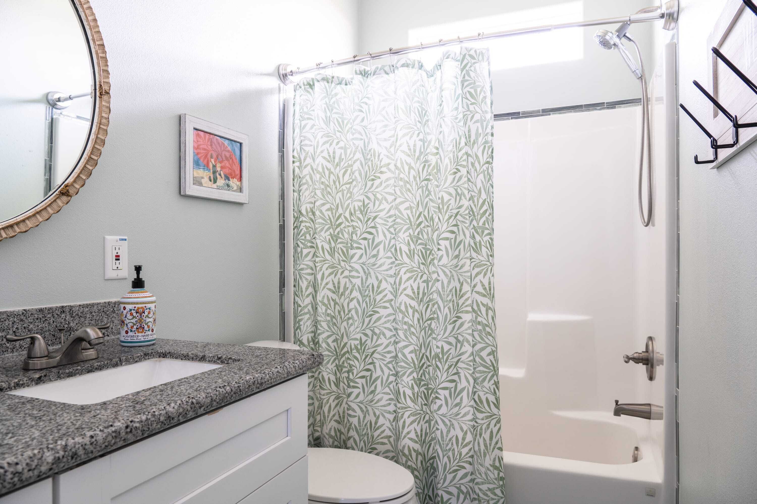 A bathroom with a shower, toilet, and sink.