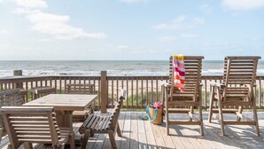 A wooden deck with a table and chairs overlooking the ocean. - Beachfront • Perfect for Groups (Bolivar Peninsula)