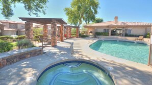 A swimming pool with a hot tub, stone pillars, and outdoor furniture. - Enjoy Paradise in this Quiet, Resort-Style 2 BR Condo (Fountain Hills)