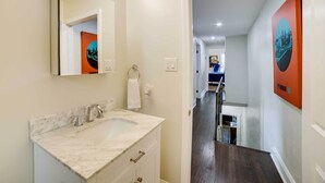 Une salle de bain avec un lavabo en marbre, un miroir et un porte-serviettes.