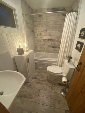 Tina con regadera, tina de hidromasaje, secadora de cabello, toallas 