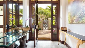 A reception area with a glass display table, wicker baskets, and a wooden bench.
