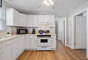 Enjoy cooking in this well-equipped kitchen with a central island, microwave, gas stove, and stainless steel sink.