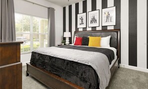 A bedroom with a large bed, a nightstand, a lamp, and a window with curtains. - Jameil's Ultimate Getaway 7mins. to Disney Theme Park (Kissimmee)