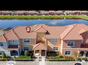 Situated by the water, this building features a uniform architectural style with red-tiled roofs and a symmetrical facade.
