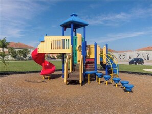 Children can play on the slide, climb the structure, and seek shelter in this park play area.
