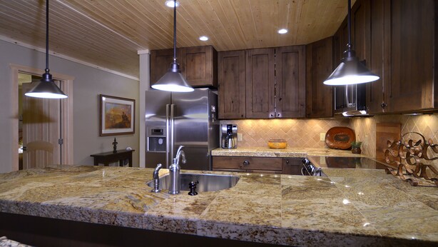 A kitchen with granite countertops, stainless steel appliances, and wooden cabinets. - Evergreen Condo | Walk to Lifts | Shared Hot Tub | Very Convinient (Mt. Crested Butte)