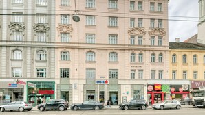 Um edifício de vários andares com estilo arquitetônico clássico, apresentando uma entrada central com uma placa que diz 'NOTARIAT'.