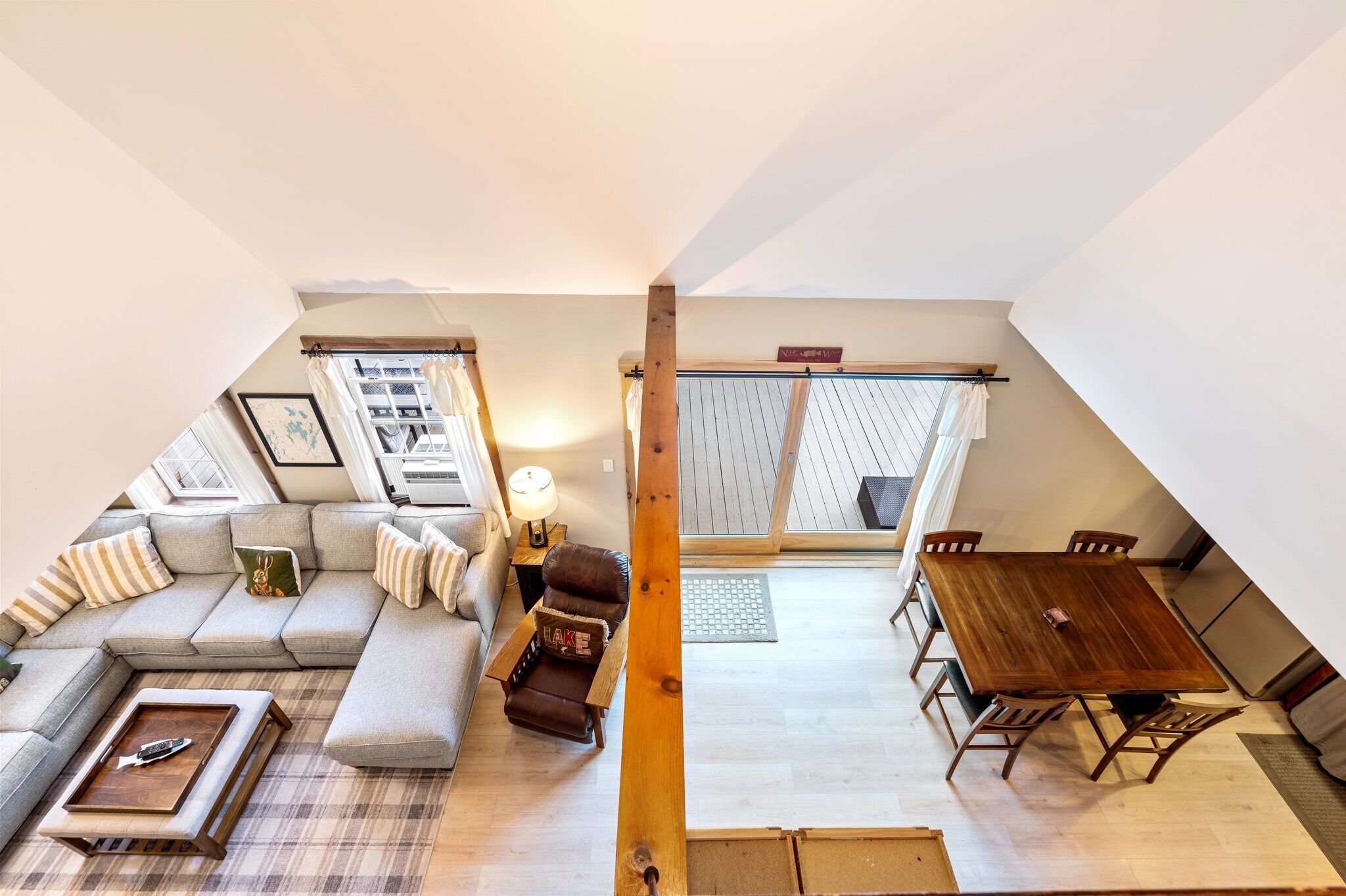 Ein Lofts-Wohnbereich mit einer Couch, einem kleinen Tisch und einem Holzessttisch mit Stühlen.