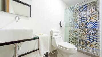 A bathroom with a bathtub, toilet, and shower.